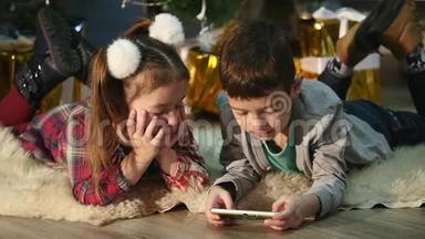 儿童在圣诞树附近玩手机、儿童和智能手机